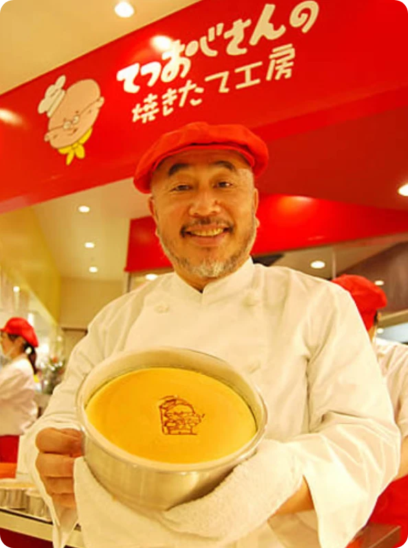 Tetsushi Mizokami, Uncle Tetsu’s founder, smiling and holding a Japanese cheesecake